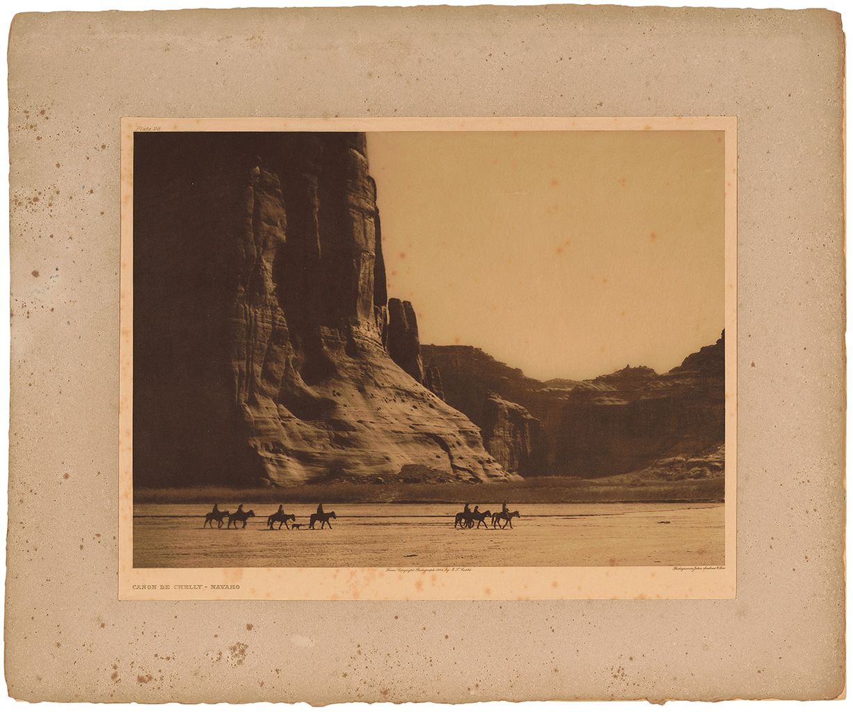 Severe foxing and yellowing has left this Curtis Plate 28 Canon de Chelly - Navaho photogravure on tissue in a fragile state.
